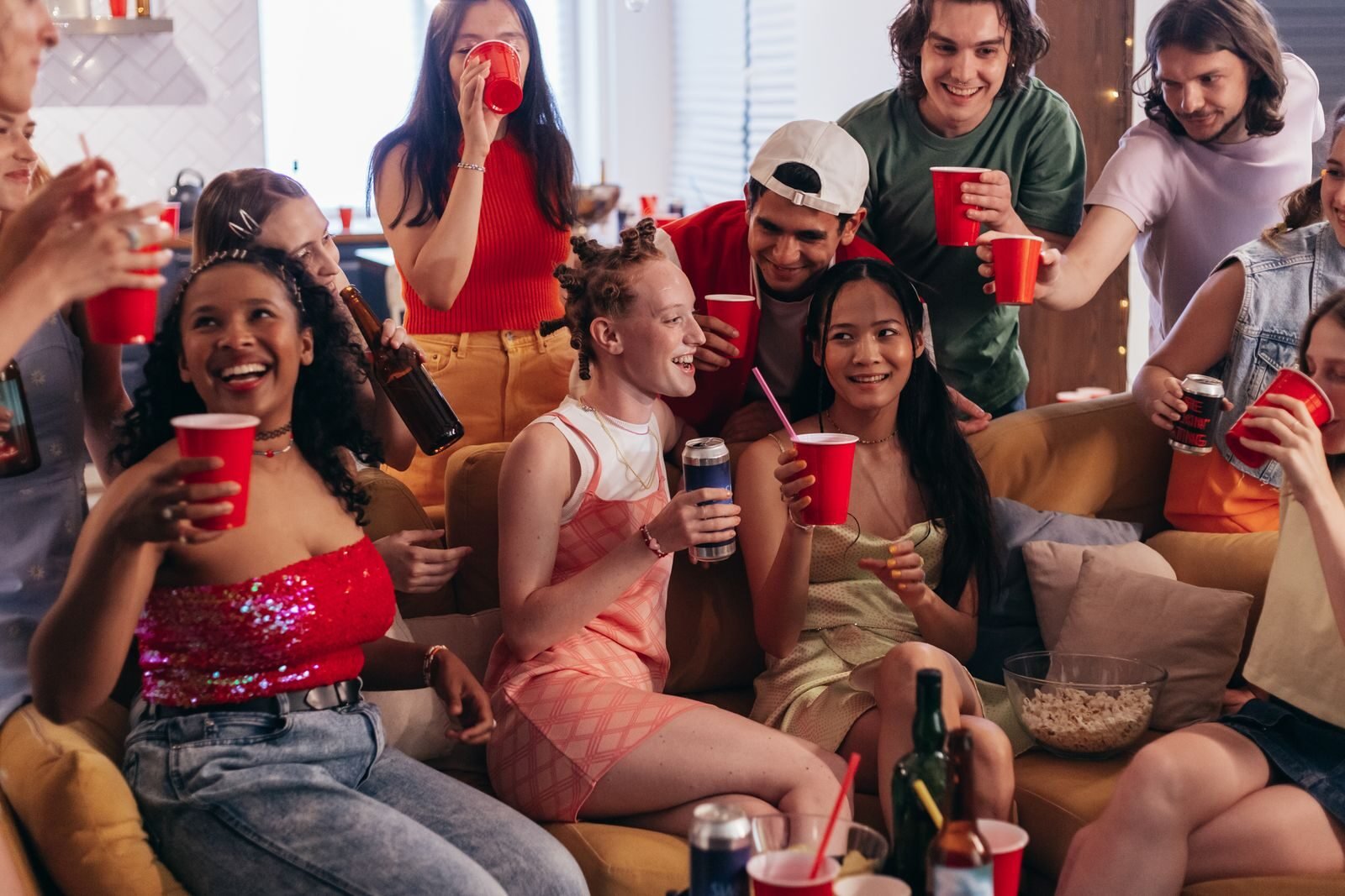 A lively indoor gathering with friends enjoying drinks and laughter.