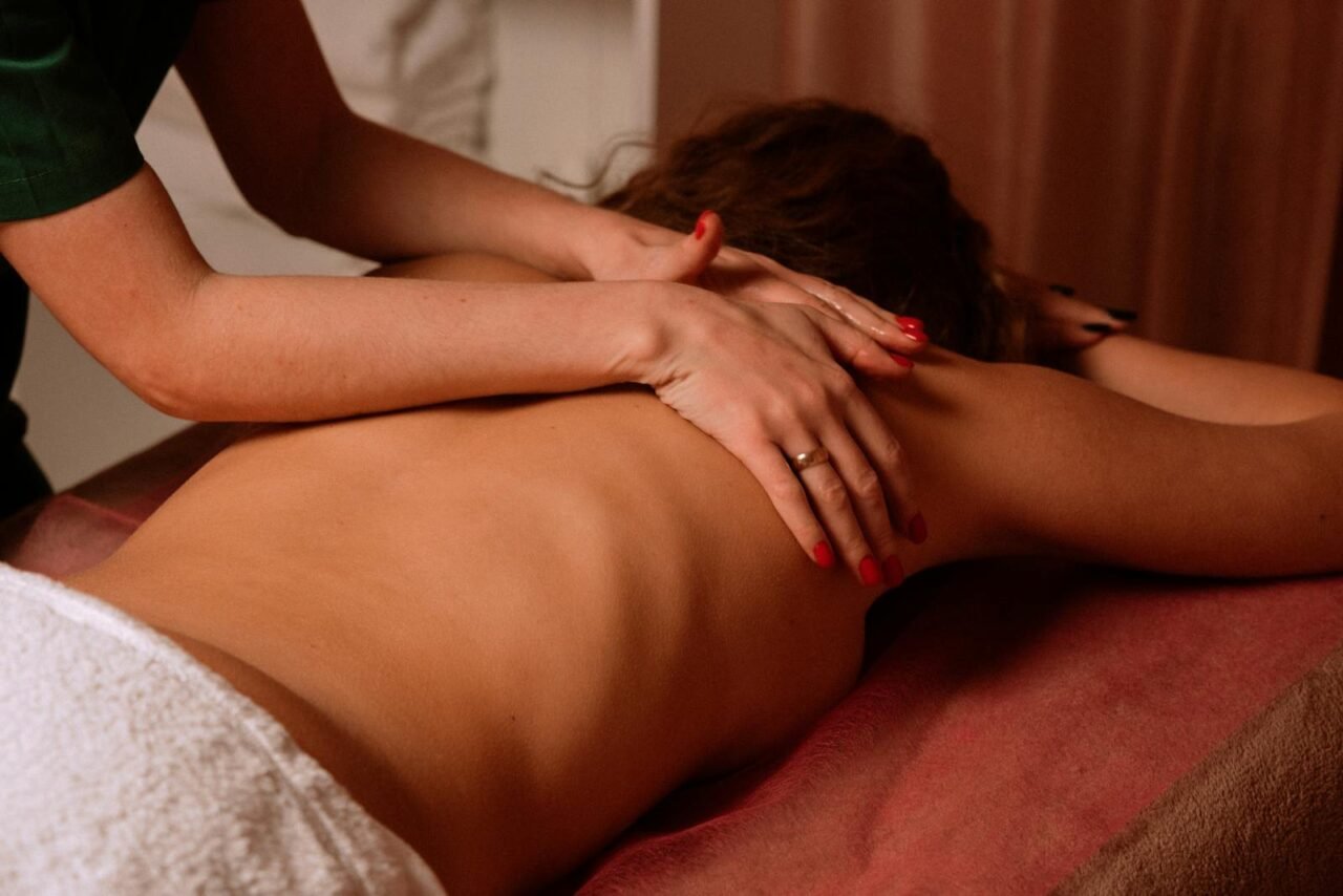 Woman receiving a soothing back massage in a serene spa environment.