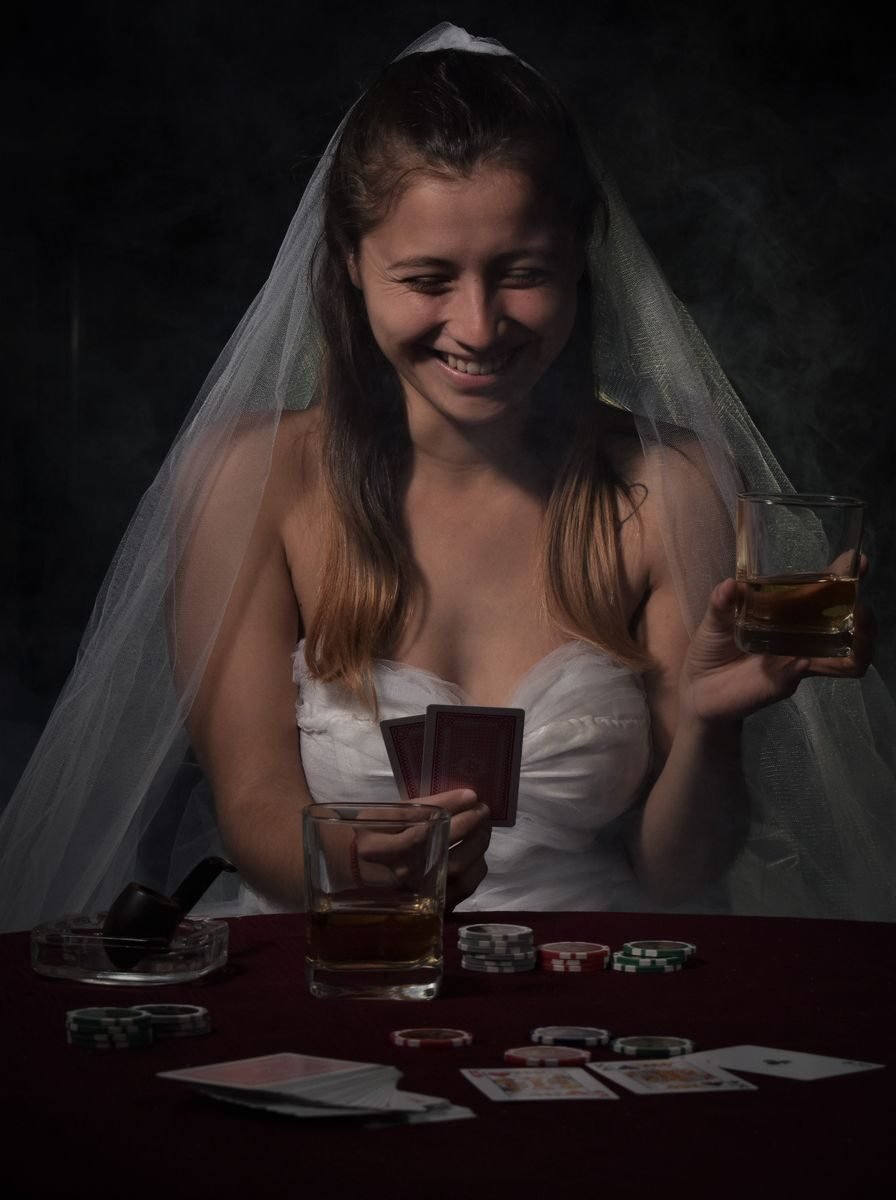 Wedding-themed poker game with bride holding cards and whiskey, showing a joyful moment.