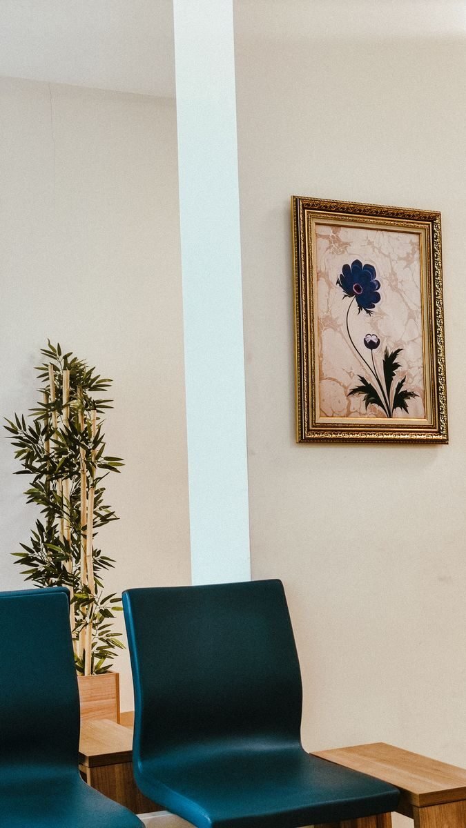 Elegant modern interior featuring blue chairs and floral wall art in a minimalist setting.