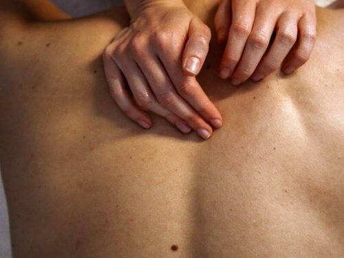 High-angle view of a soothing back massage therapy session highlighting expert hand techniques.