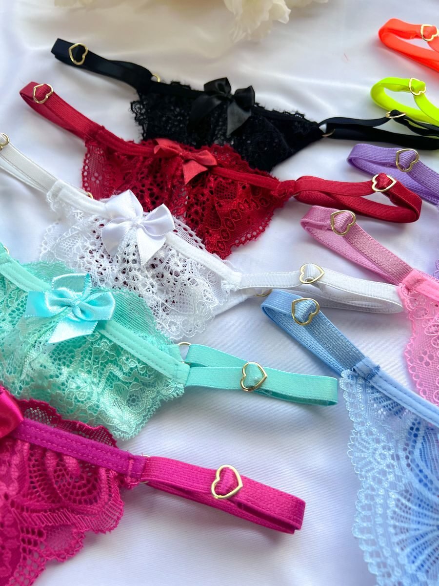 A vibrant collection of lace panties with heart accents and bows arranged on a white surface.