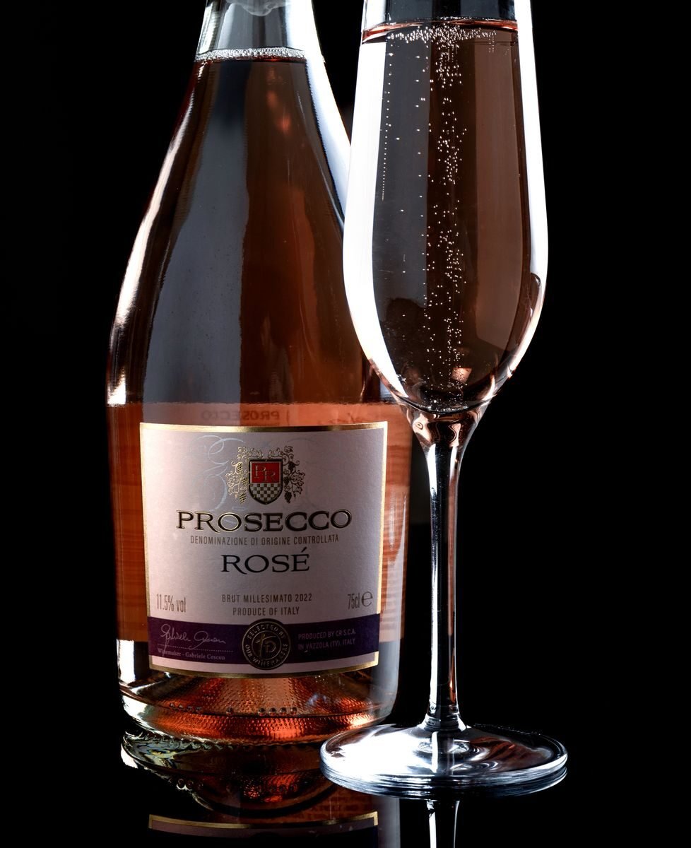 Close-up of a Prosecco Rosé bottle with a filled flute glass, showcasing sparkling bubbles.