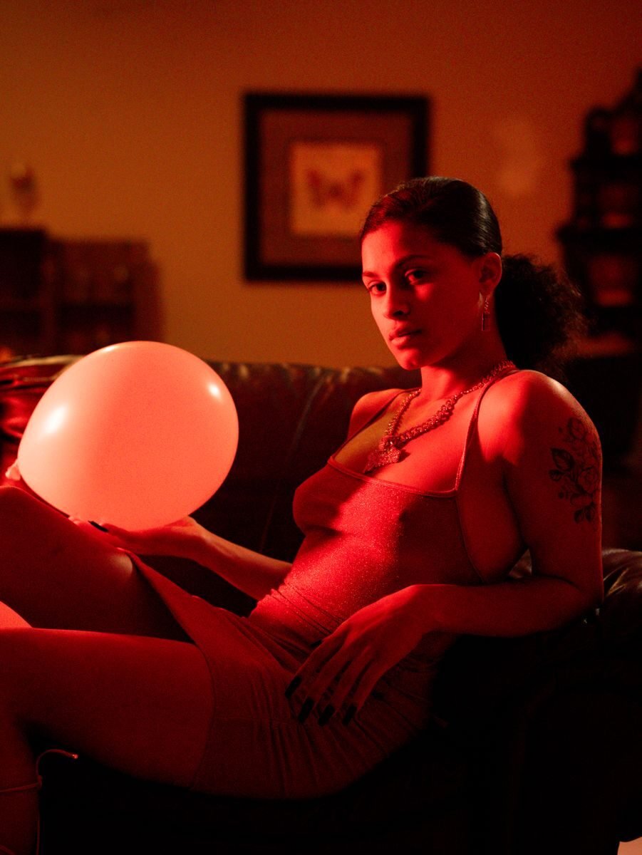 Cinematic portrait of a young woman in red lighting, capturing a moody ambiance.