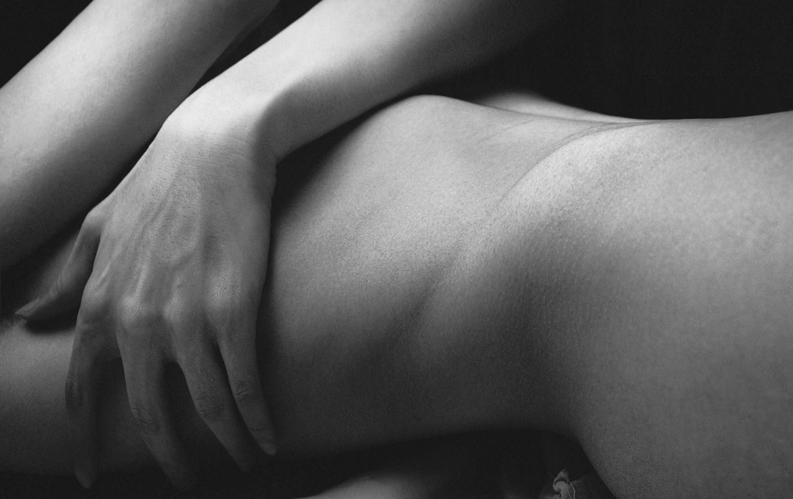 A delicate black and white close-up of a woman's body emphasizing form and texture.
