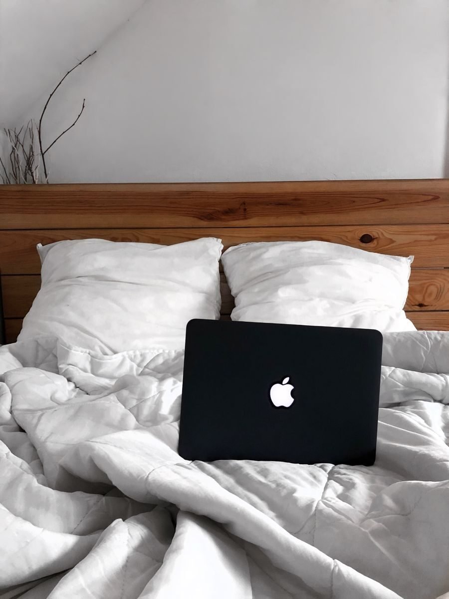A comfortable bed with a laptop, perfect for remote work or leisure in a cozy bedroom setting.