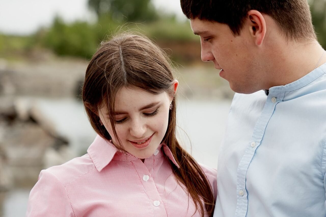 Close-up of a young couple, sharing a tender moment outdoors, expressing love and connection.