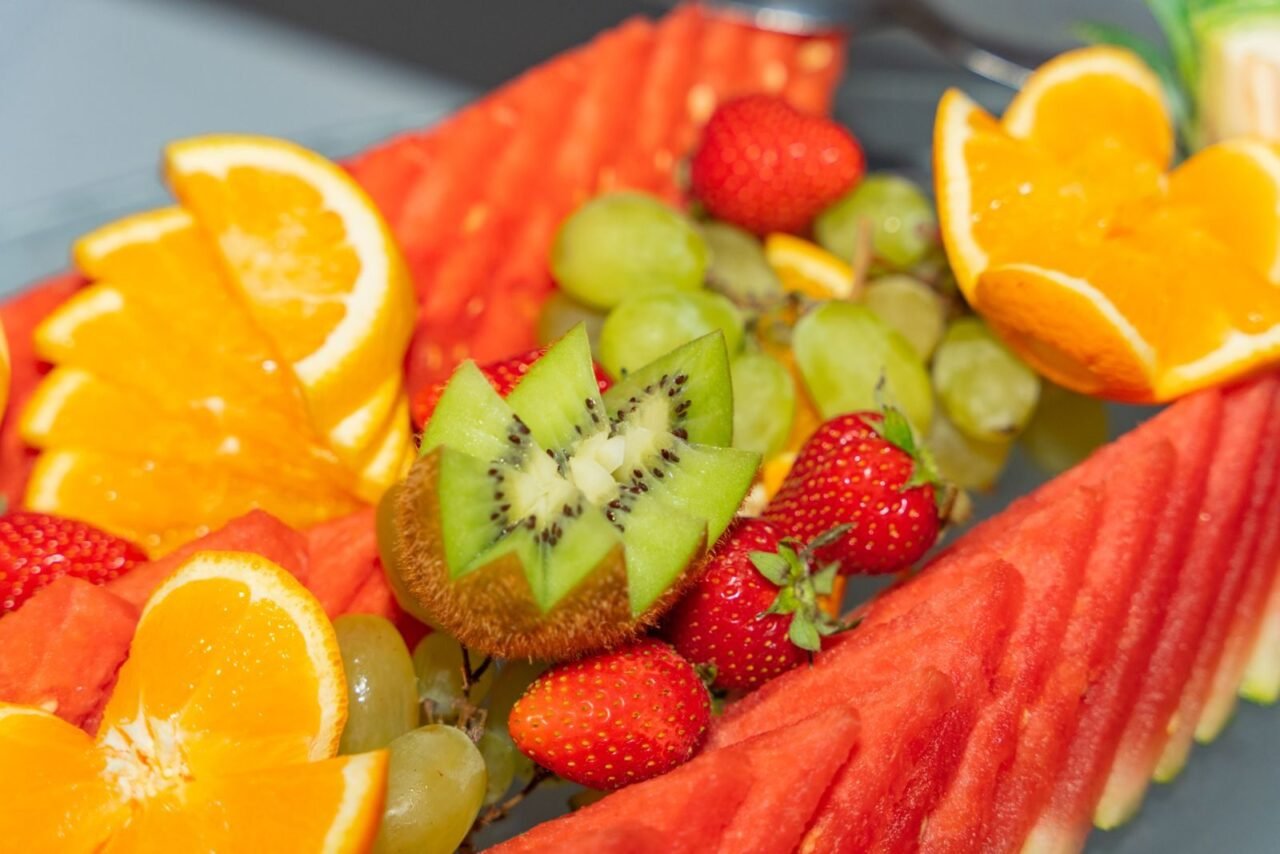 Fresh tropical fruits including watermelon, oranges, and kiwi arranged beautifully.