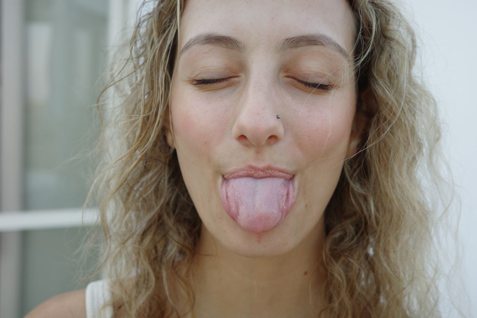 A fun portrait of a young woman sticking out her tongue playfully in Paros, Greece.