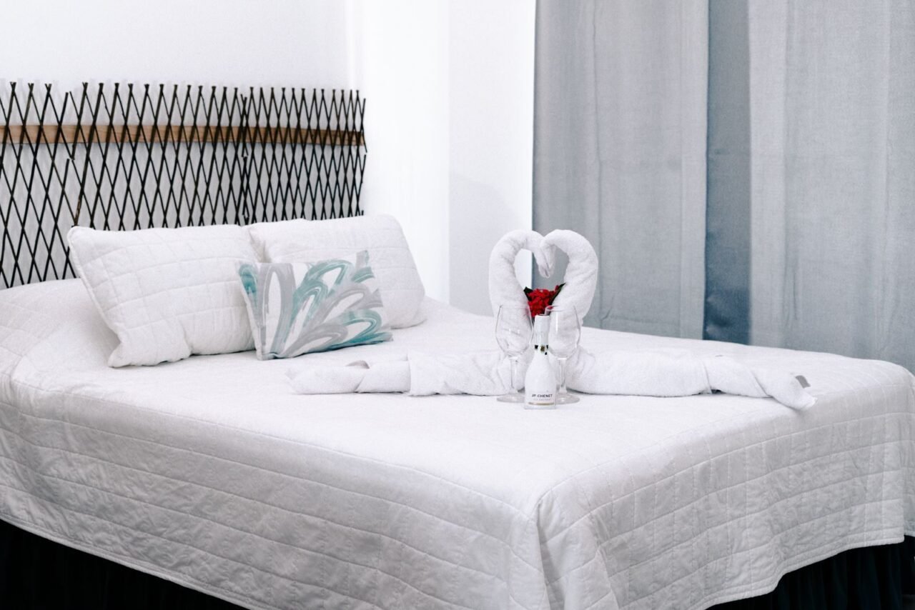 A beautifully decorated honeymoon suite featuring towel swans, red roses, and champagne glasses.