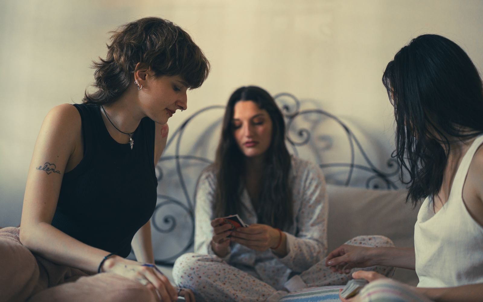 Three women enjoy a card game in a relaxed, cozy indoor setting.