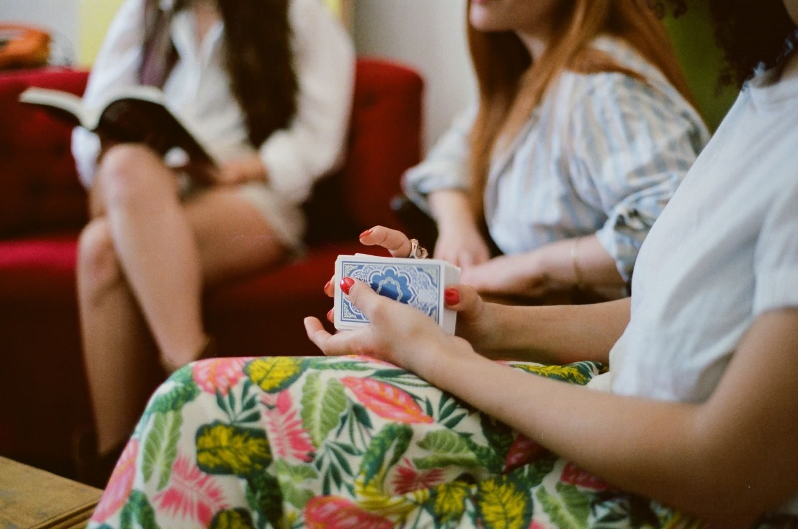 Group of friends enjoying a relaxed card game in a comfortable living room environment.