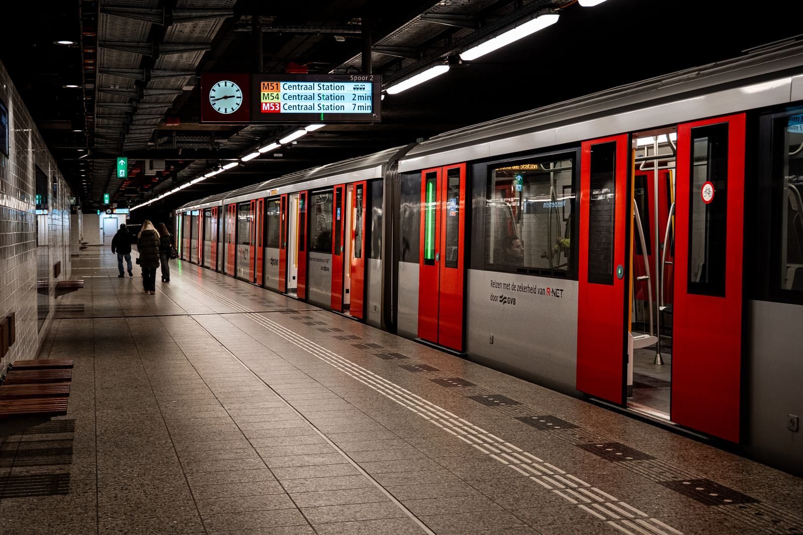 Snapshot of a metro station platform with a train bound for Centraal Station in a bustling city.