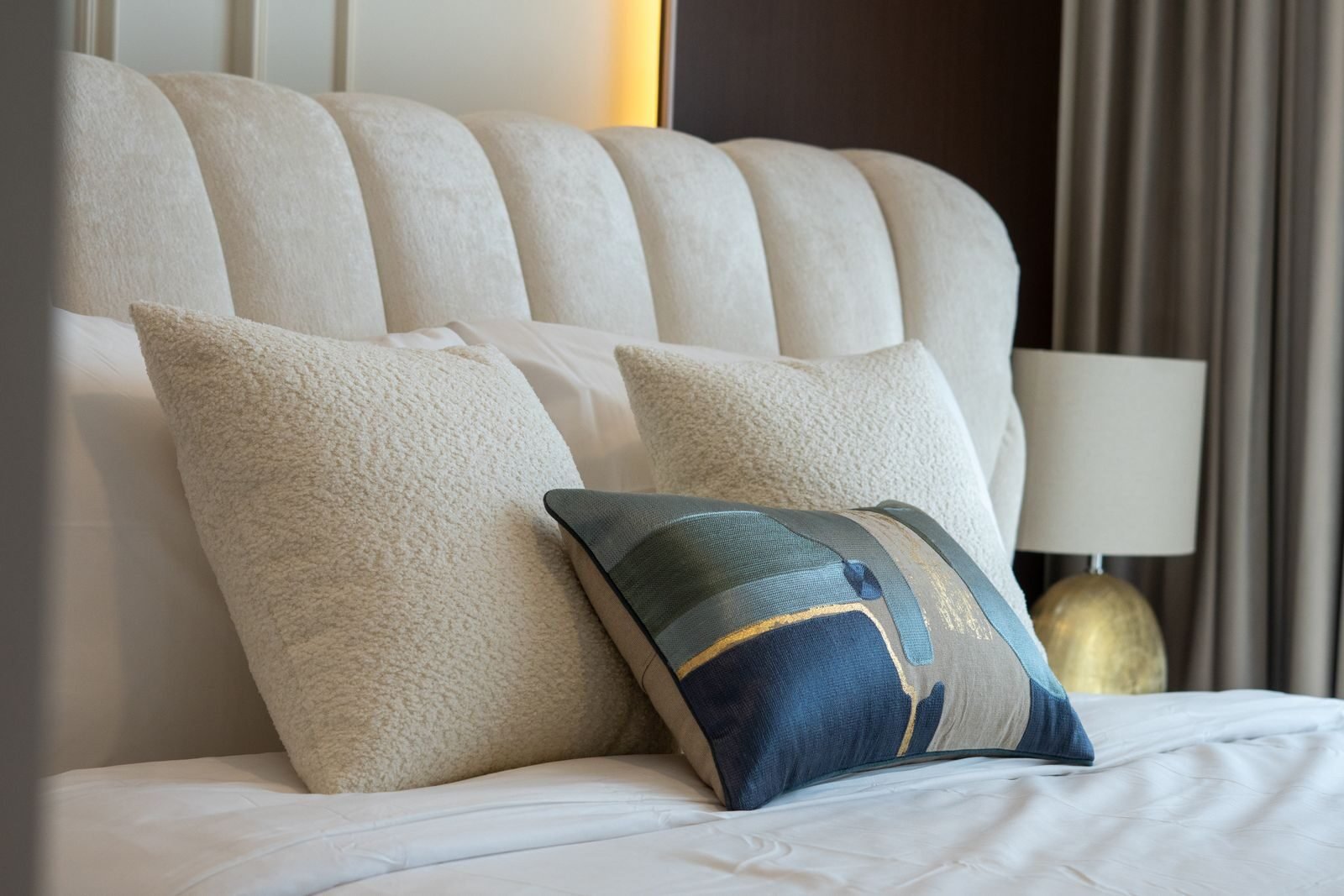 Stylish bedroom setting featuring a luxurious headboard and textured pillows for a modern look.