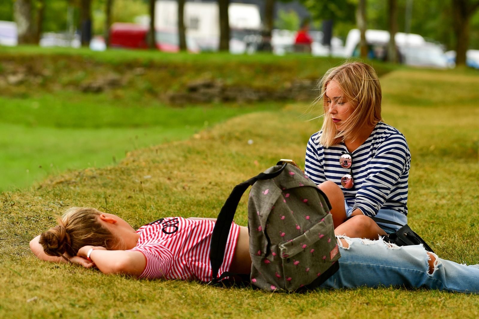 Two teenagers enjoying a summer day on grass in Kuressaare, Estonia.