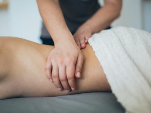 Close-up of a woman receiving a therapeutic massage in a serene spa setting with a white towel.