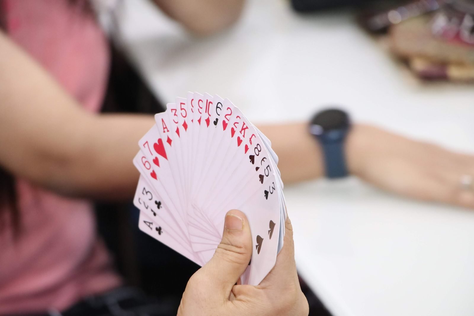 Close-up of a person holding a fan of playing cards, perfect for game or poker-related visuals.