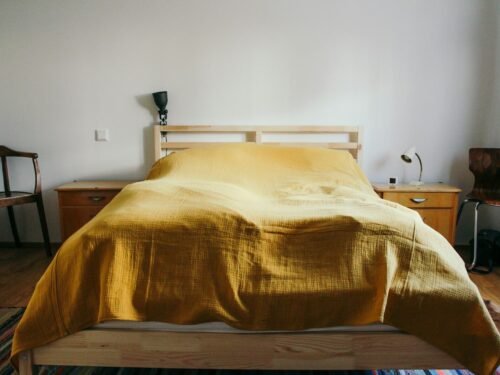 a bed with a yellow comforter in a bedroom