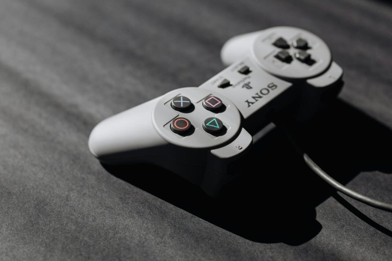 Retro Sony game controller with classic buttons on a textured dark surface, showcasing vintage electronics.
