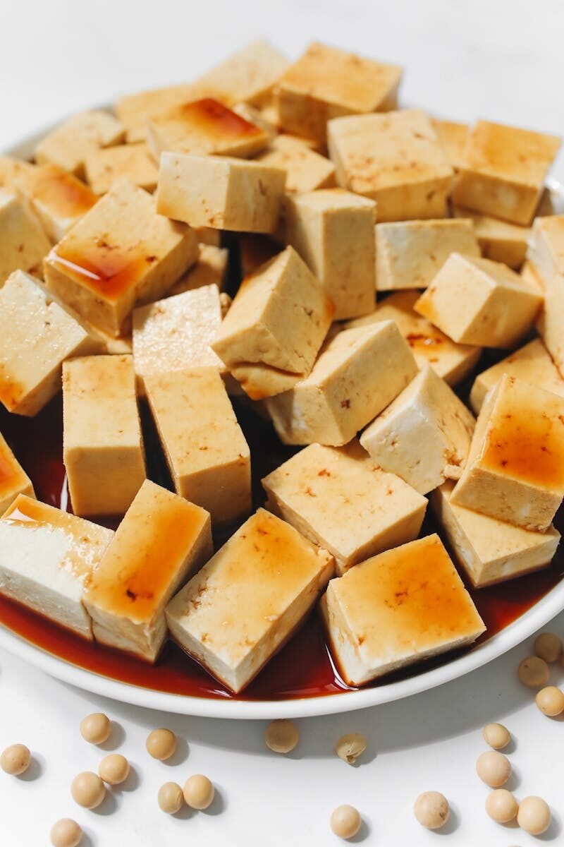 Sliced tofu cubes drenched in soy sauce, perfect for a delicious and healthy meal.