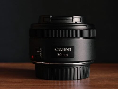 black nikon camera lens on brown wooden table