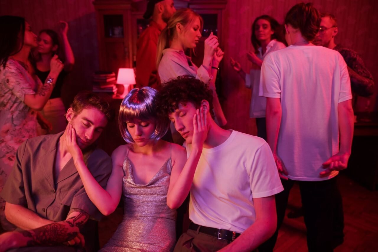 Group of young adults enjoying a lively night party with neon lights and retro vibes.