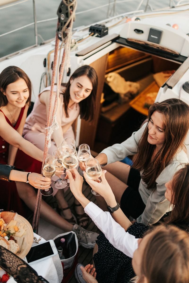 A joyful group of women toasting with wine aboard a yacht, embodying leisure and friendship.
