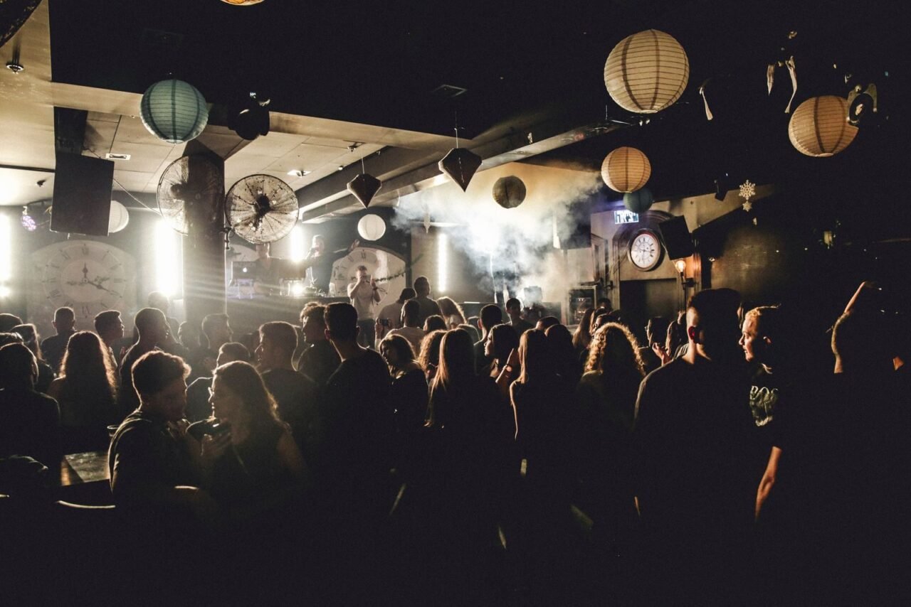 Vibrant nightlife scene showcasing people dancing in a lively nightclub under dynamic lighting.