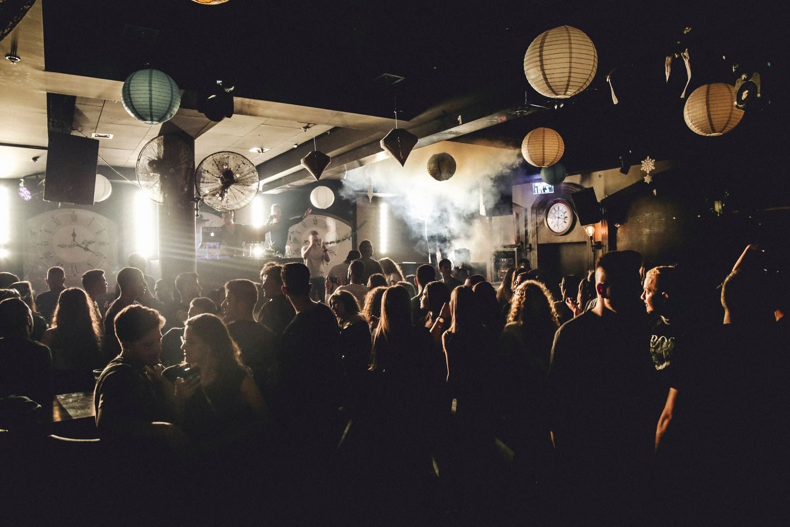 Vibrant nightlife scene showcasing people dancing in a lively nightclub under dynamic lighting.