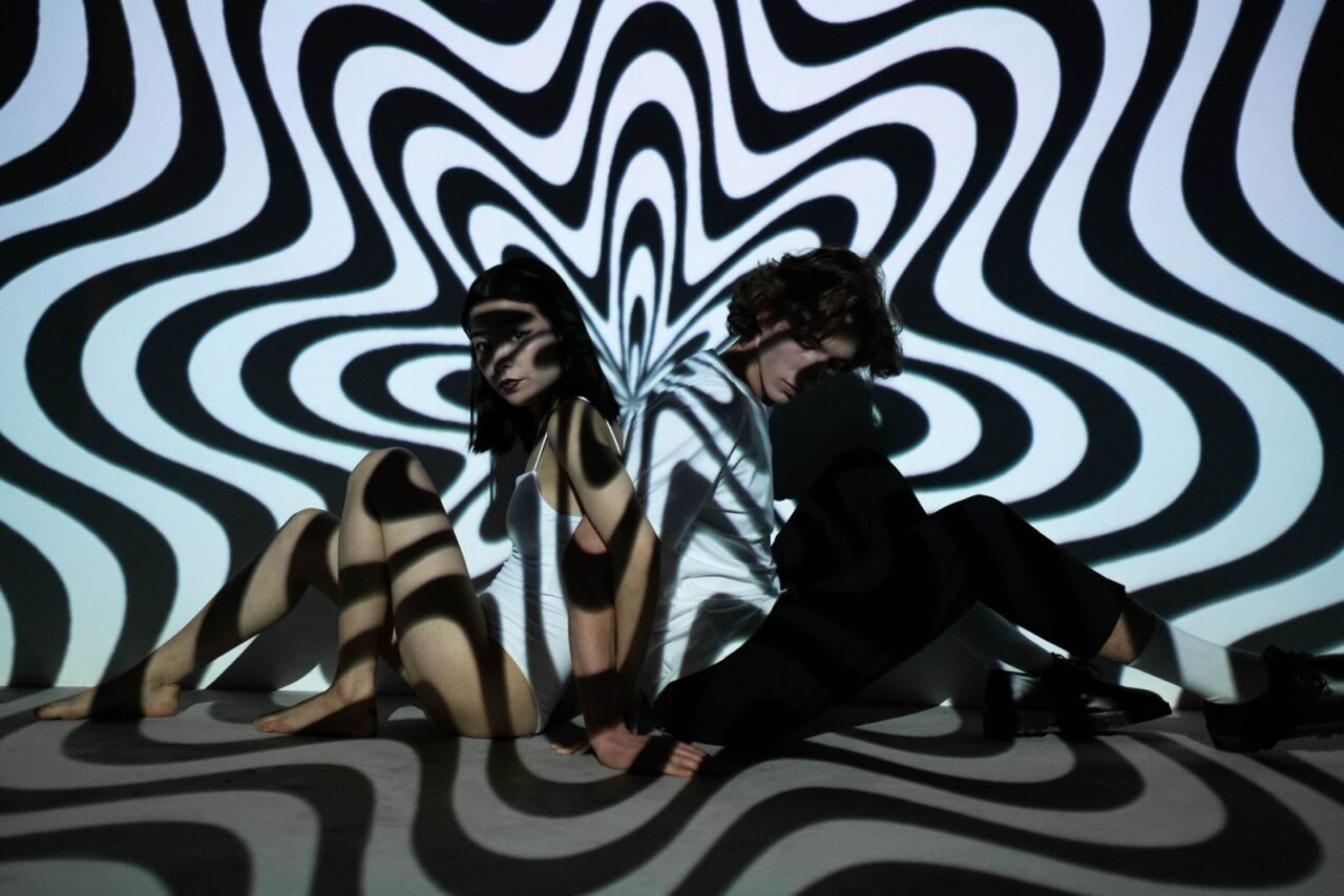 A vibrant double exposure featuring a man and woman with captivating optical illusions and abstract patterns.