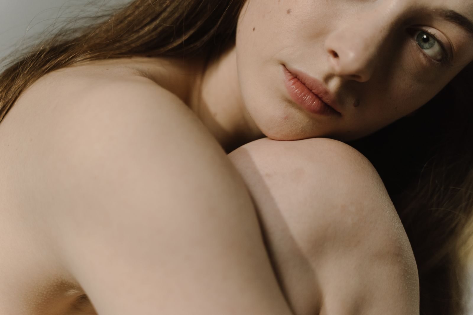 Sensual close-up portrait of a woman with bare skin and intimate expression, highlighting natural beauty.