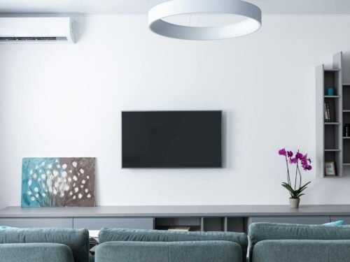 Contemporary living room decorated with purple flowers and rectangular shaped shelves handing on wall