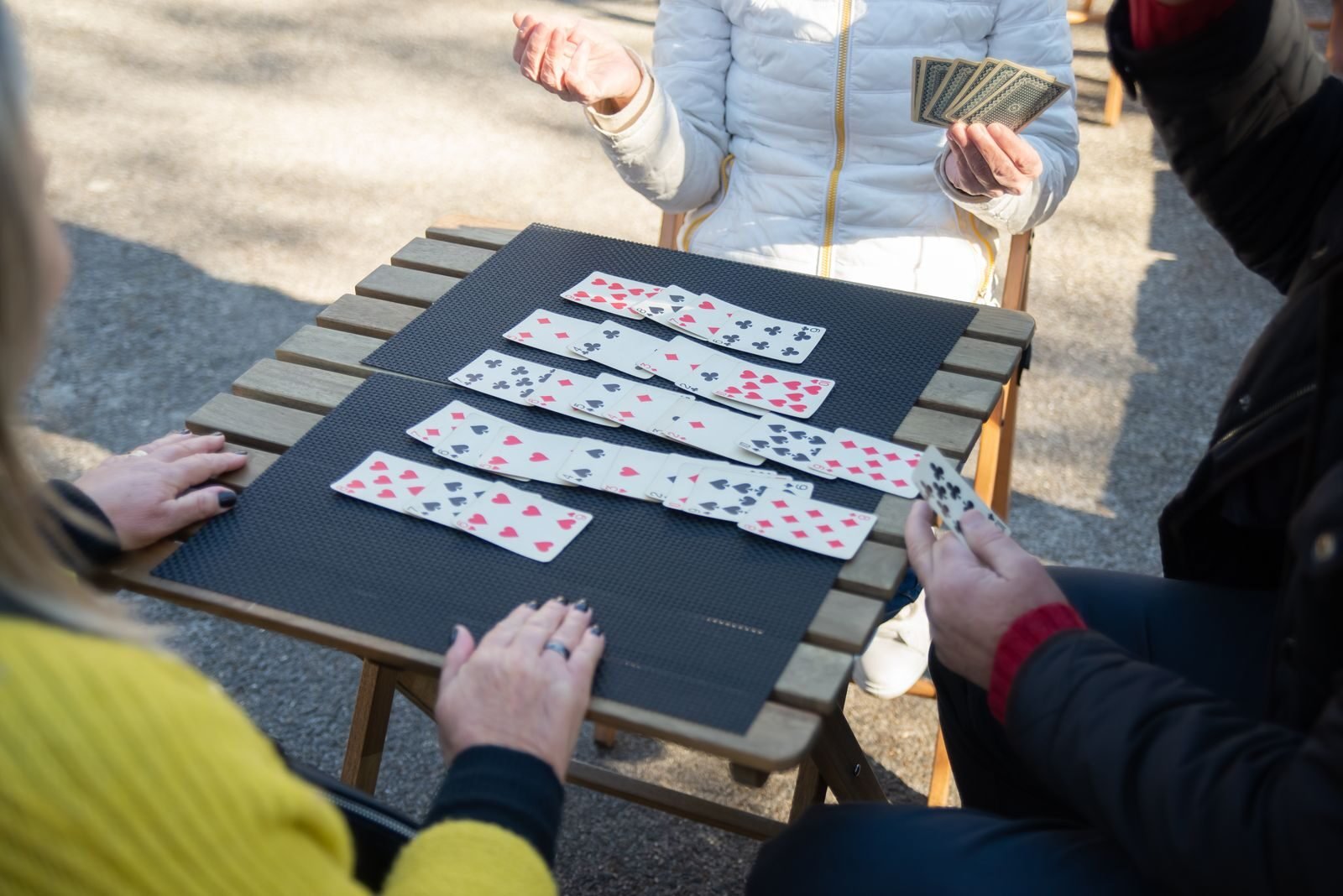 People playing an outdoor card game in Portugal, enjoying leisure time.