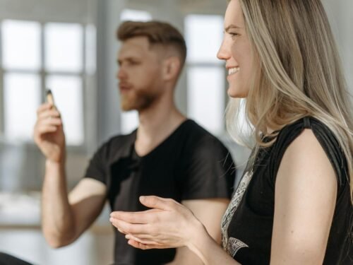 Two adults practicing meditation indoors with natural light and focus on mindfulness.