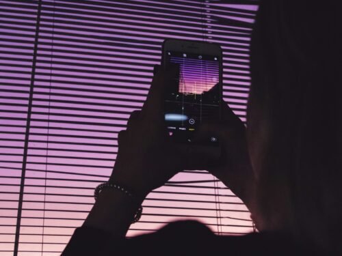 person taking picture of the purple sky using a smartphone