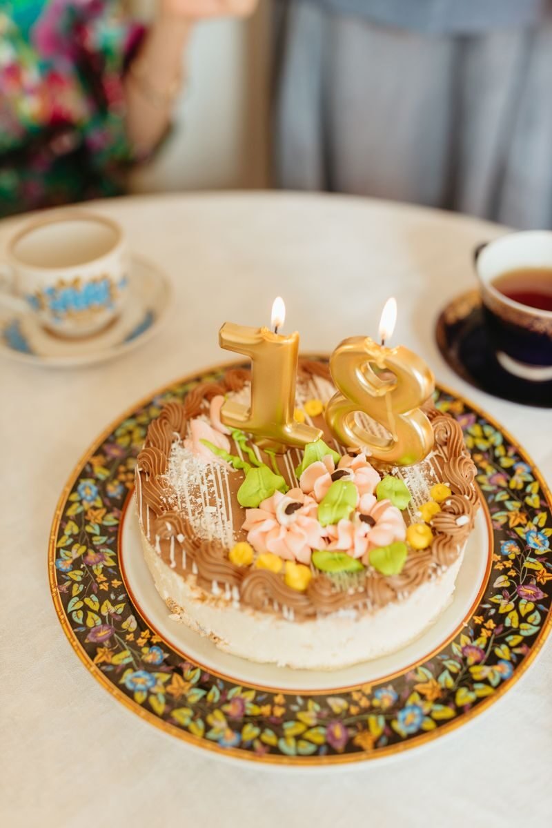 Celebrate a special milestone with an elegant 18th birthday cake adorned with golden candles and floral decorations.