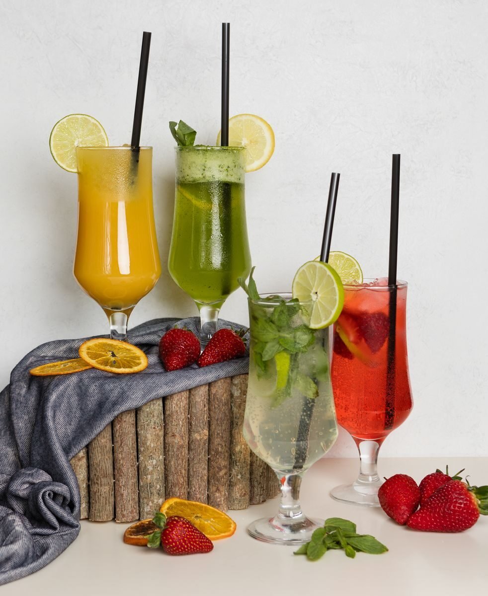 Colorful tropical cocktails with fruits and mint leaves in tall glasses. Perfect for summer refreshment.