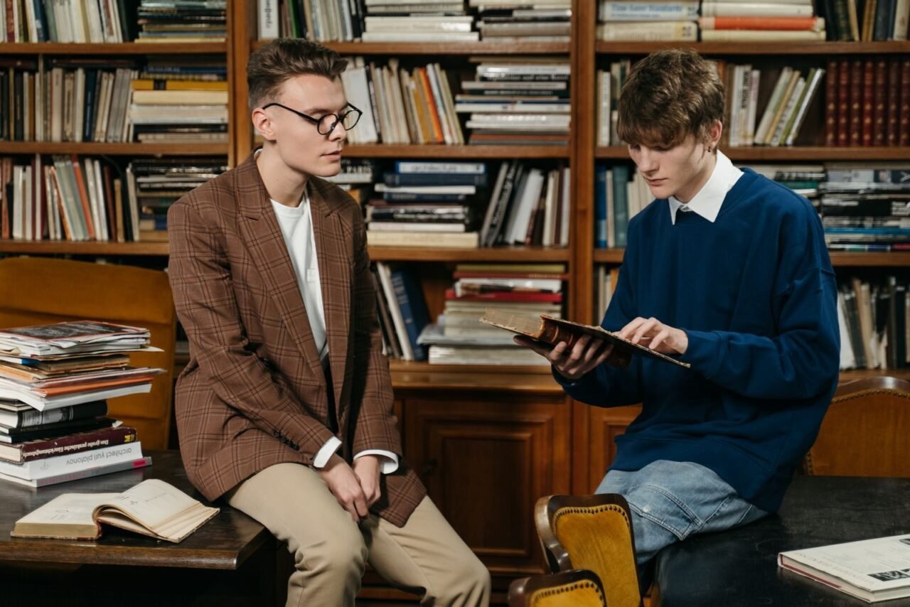 Students engage in reading and discussion in a cozy library environment.