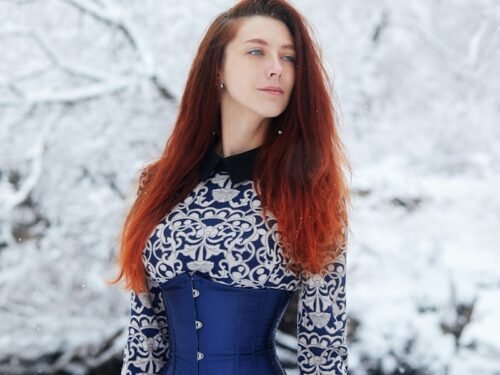 woman in black and white long sleeve dress standing on snow covered ground during daytime
