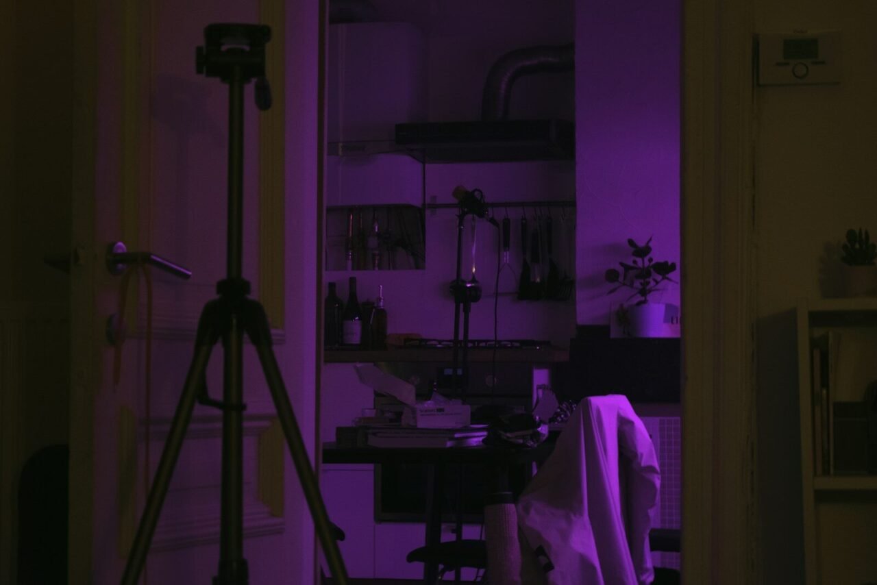 a room with a purple light and a tripod