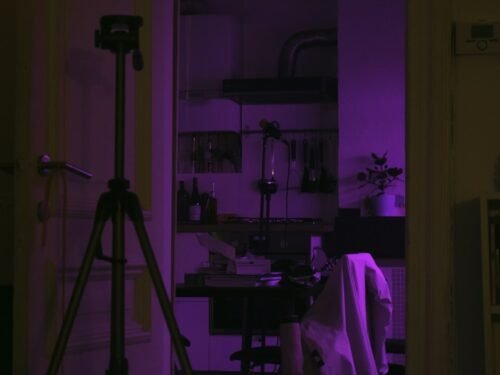 a room with a purple light and a tripod