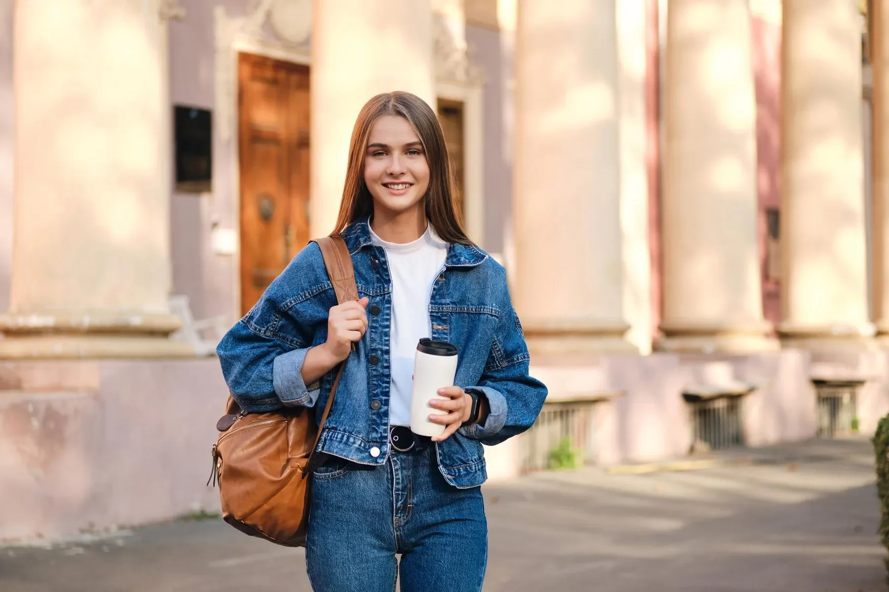 Attractive smiling casual student girl denim jacket with backpack