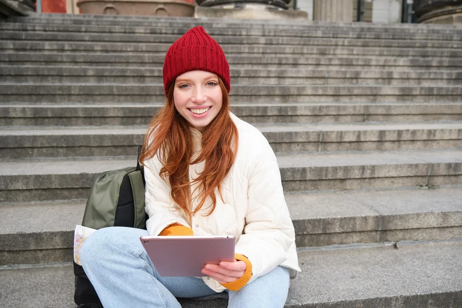Beautiful young modern girl with red hair holds digital