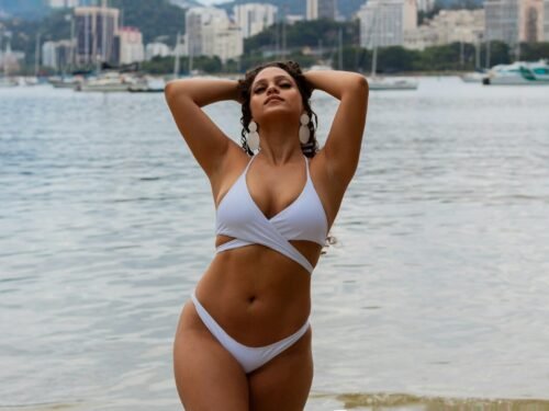 a woman in a white bikini standing on a beach