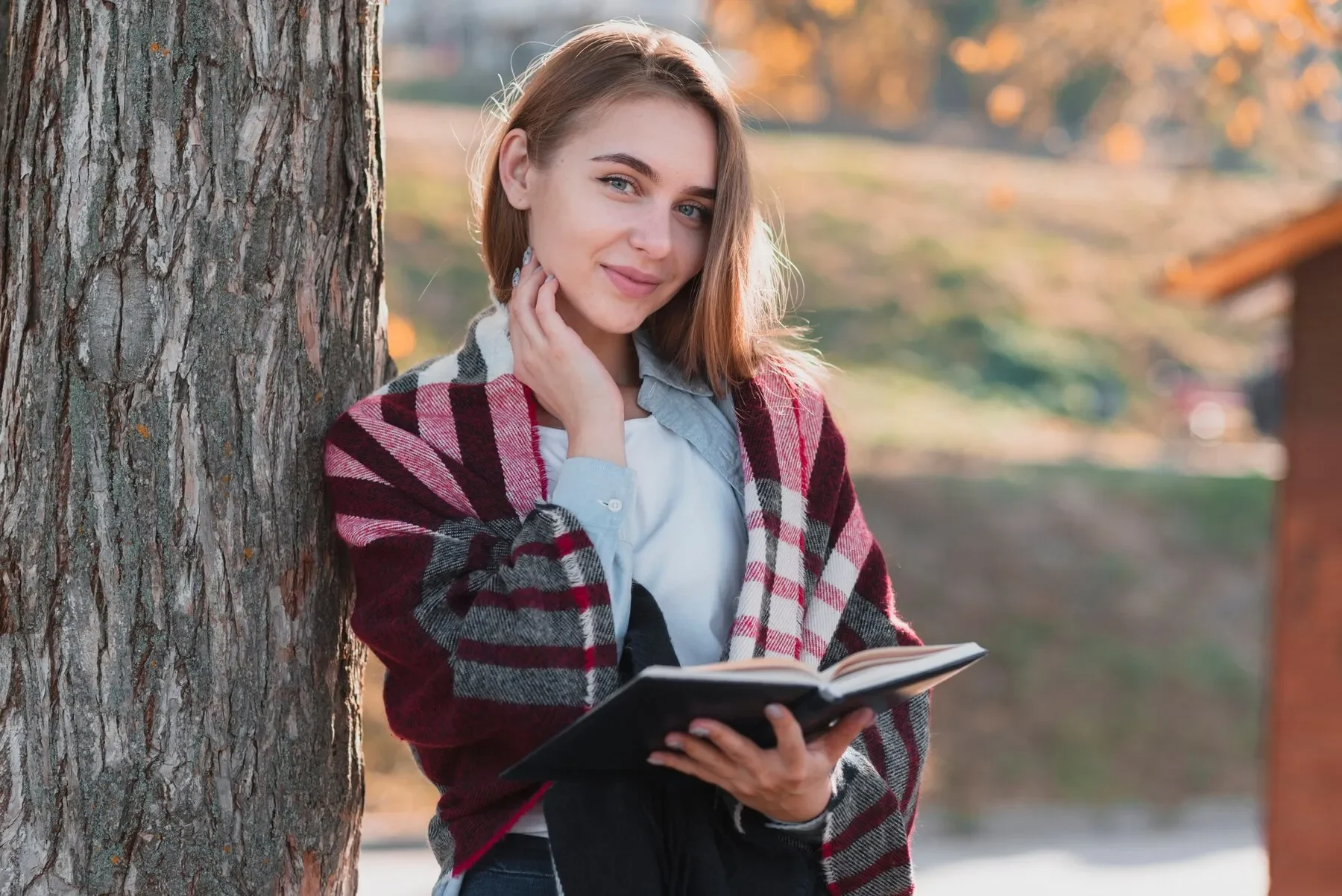 Blonde woman holding notebook looking photographer