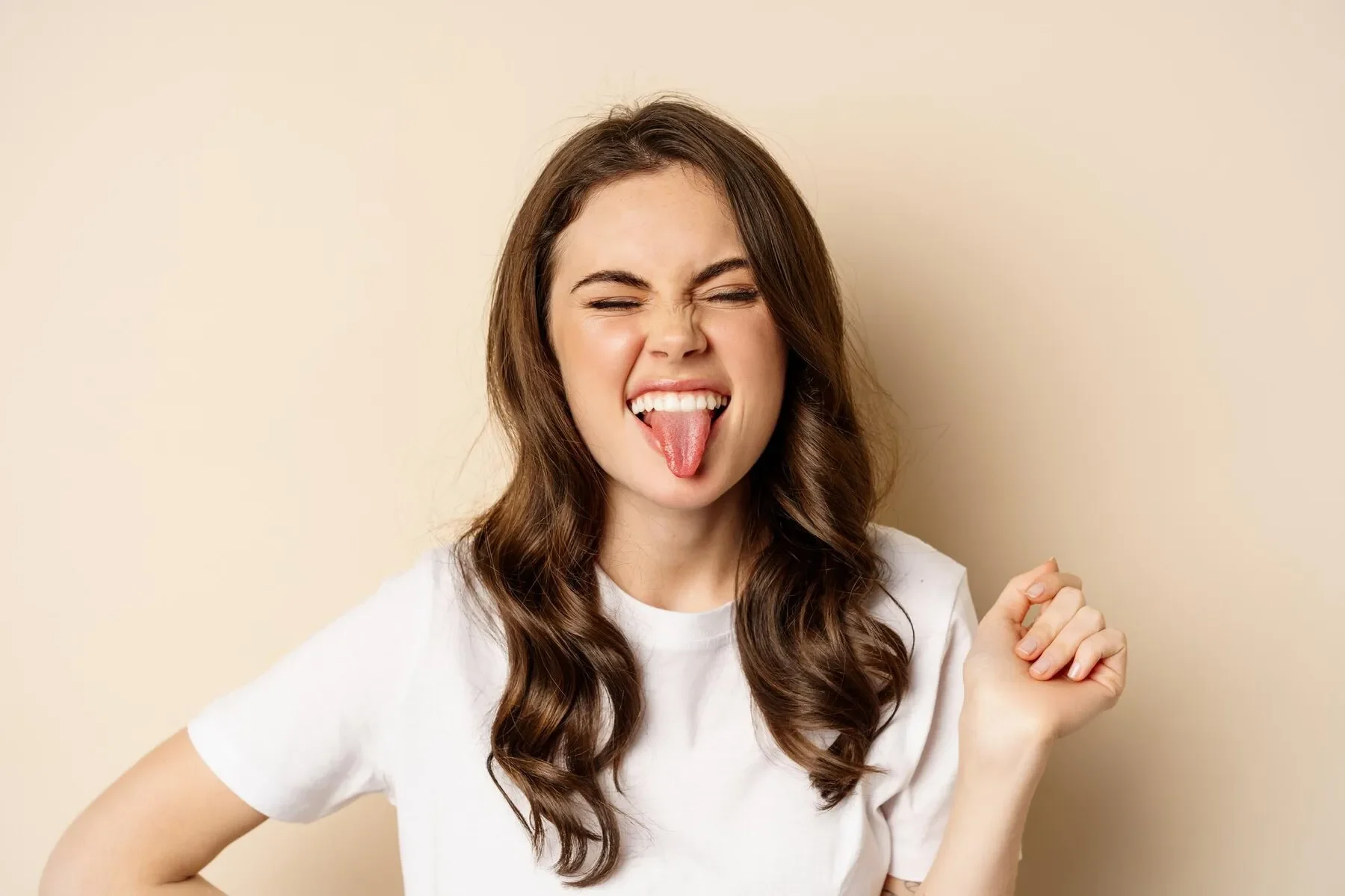 Close up happy carefree beautiful woman posing silly showing tongue