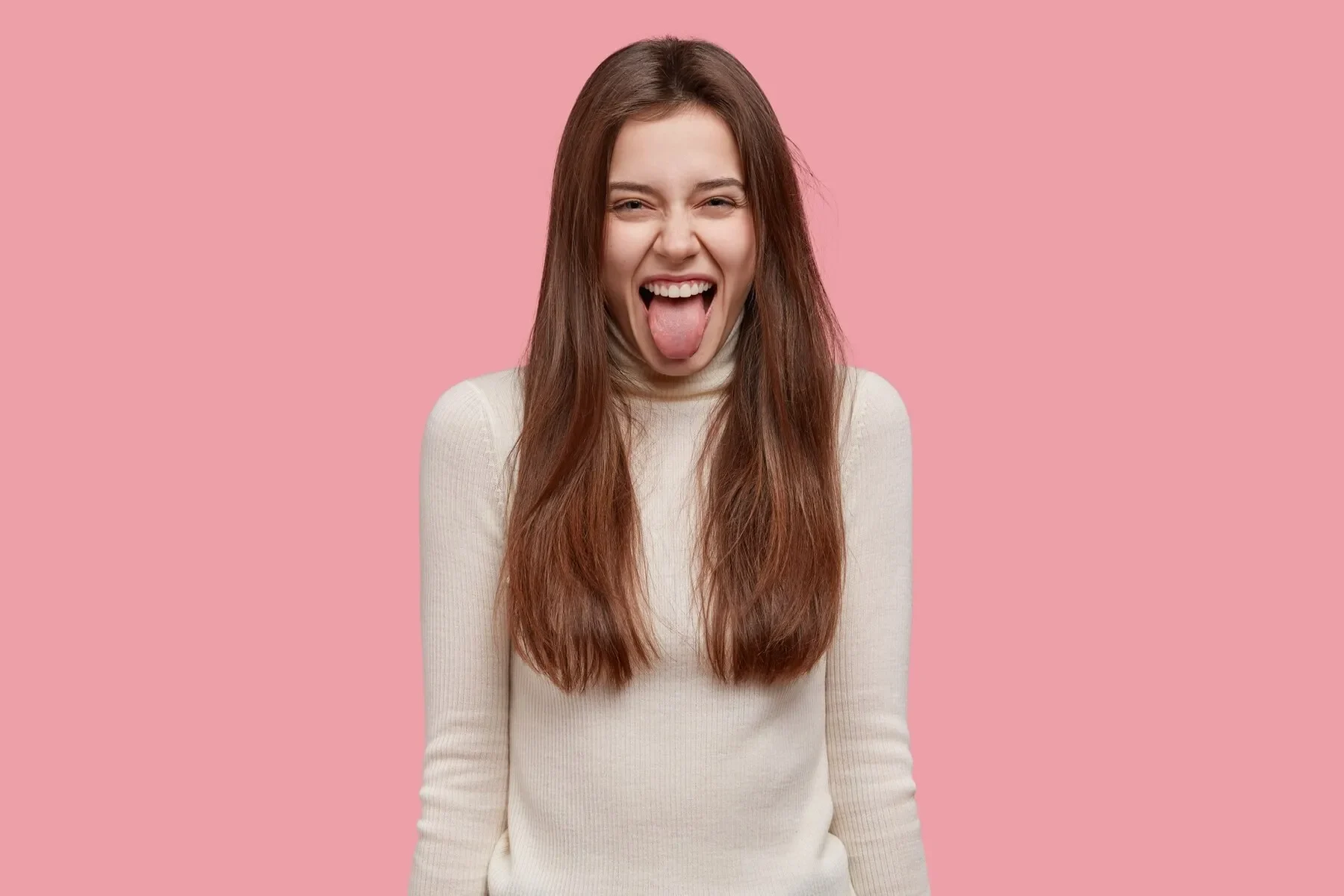 Comic young female model sticks out tongue