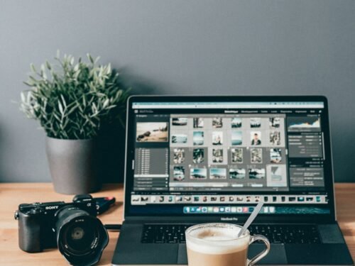 black laptop computer beside white ceramic mug on brown wooden table