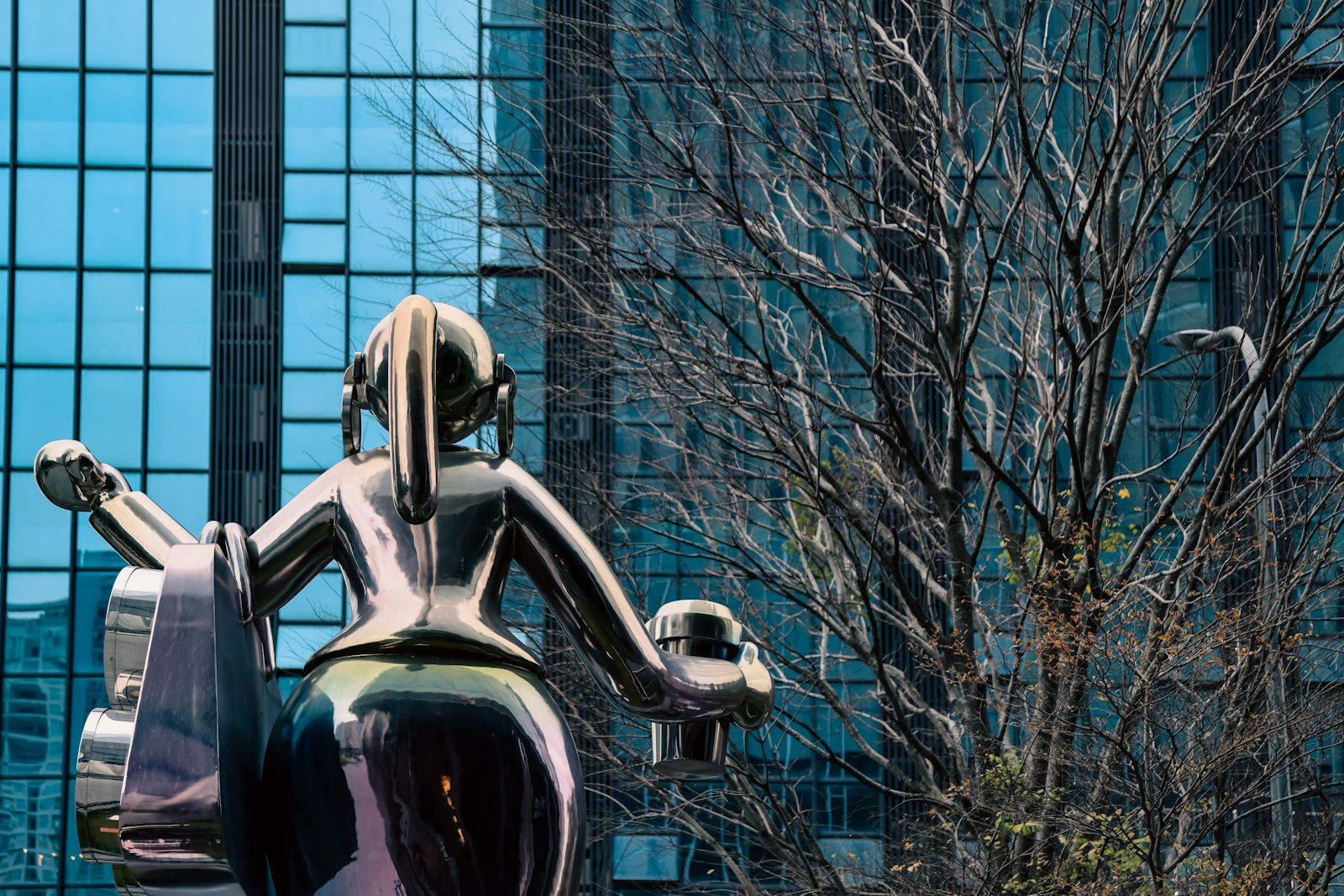 a statue of a person sitting on a bench in front of a building