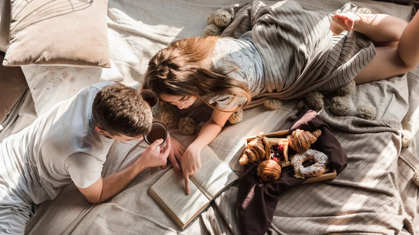 Elevated view couple lying bed reading book 23 2147966488 result